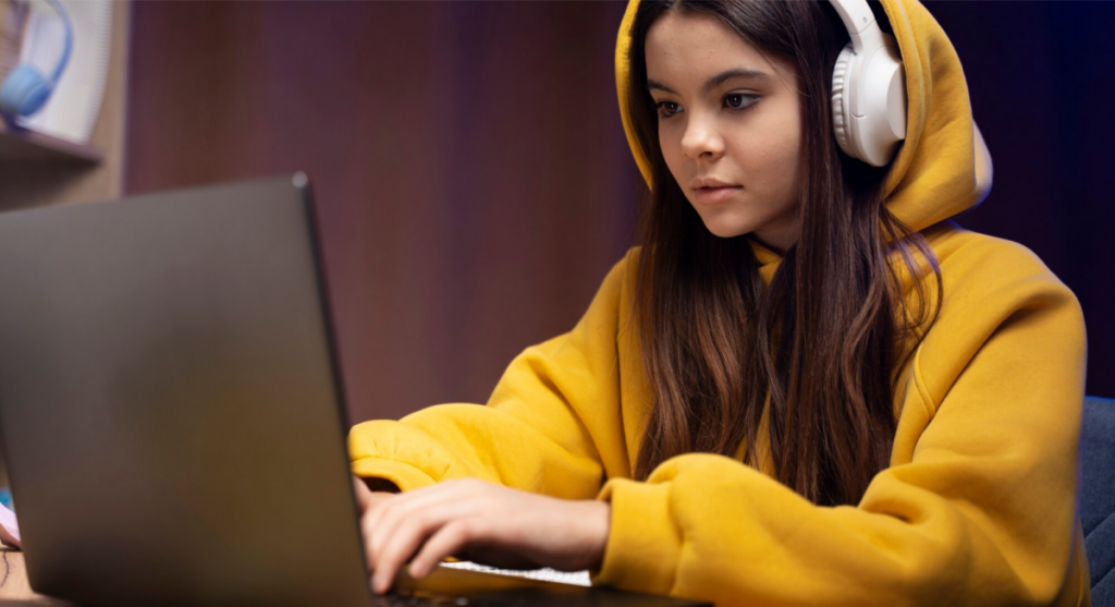 An image of a young person focused on laptop screen, symbolizing the challenge of mastering when to use the comma vs period.