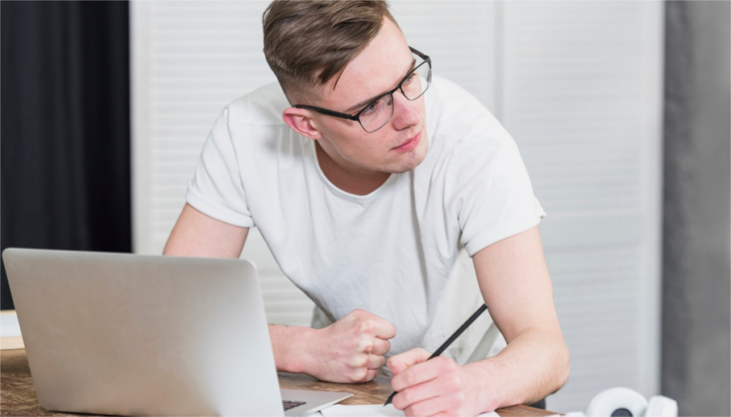 Image of a focused young man at a desk, writing with a pencil, symbolizing his effort to understand and master punctuating complex sentences.