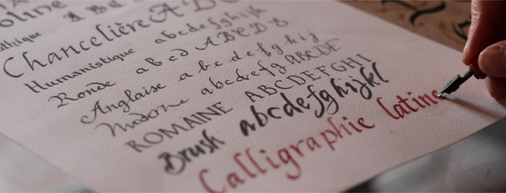 An image of a person practicing Latin calligraphy, symbolizing the blend of art and writing inspired by the Hedera Punctuation Mark.